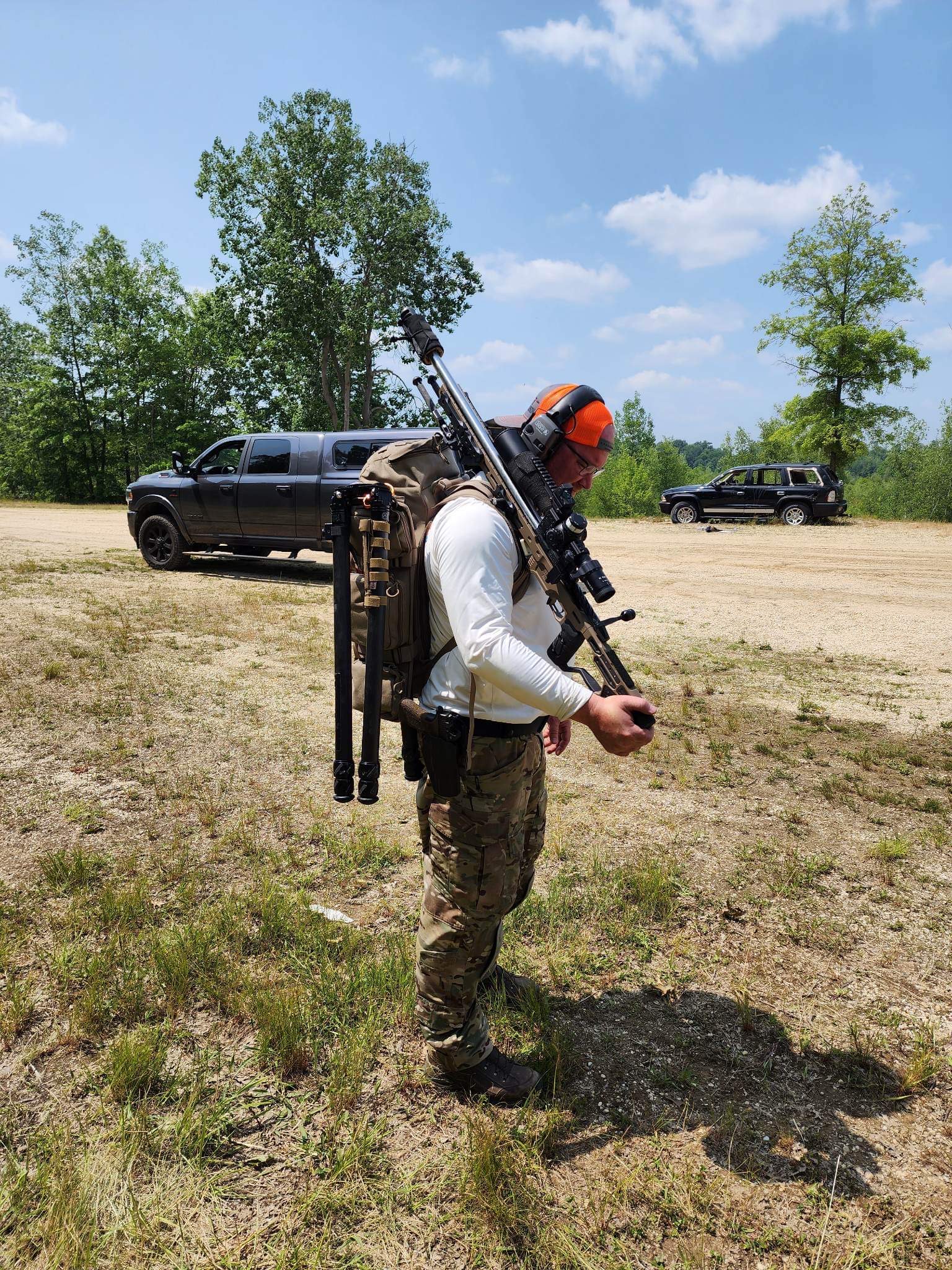 Shooter carrying precision rifle equipment outdoors