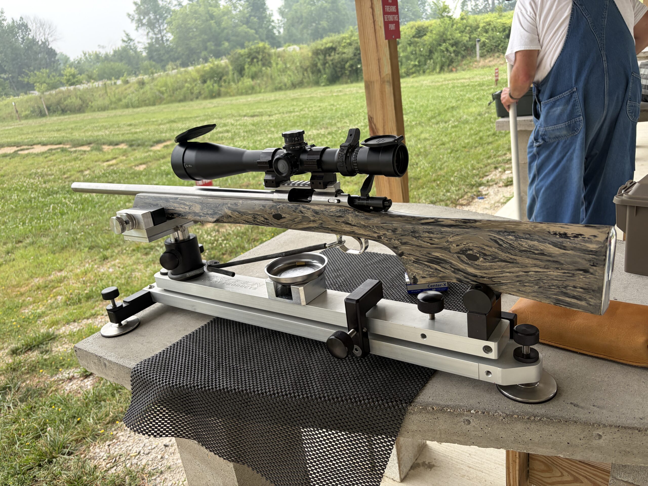 Precision rifle on a rest at an outdoor shooting bench